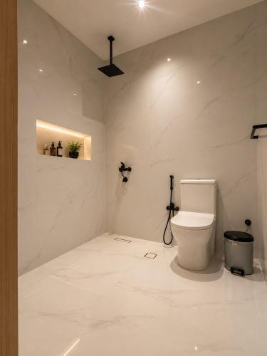 ein weißes Badezimmer mit Toilette in einem Zimmer in der Unterkunft رأس الشفا - OrbitNet in Al Shafa
