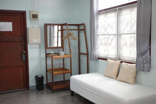 a room with a bed and a shelf next to a window at โรงแรมยุติชัย in Prachuap Khiri Khan