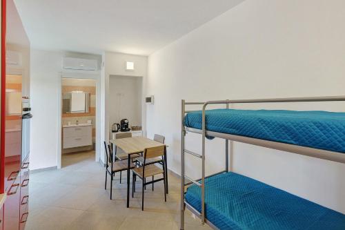 a room with two bunk beds and a table and chairs at Mammina Holiday Home in Casal Velino