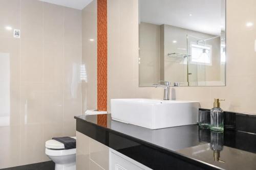a bathroom with a sink and a toilet and a mirror at Luxurious Penthouse Pattaya in Pattaya South