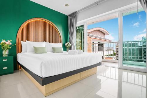 a bedroom with a large bed and a green wall at Luxurious Penthouse Pattaya in Pattaya South