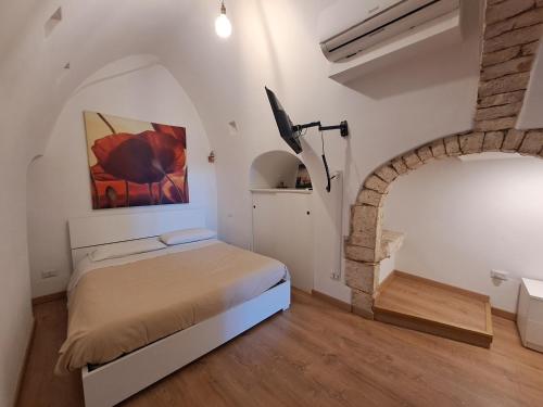 a bedroom with a bed and a painting on the wall at A Levante in Putignano
