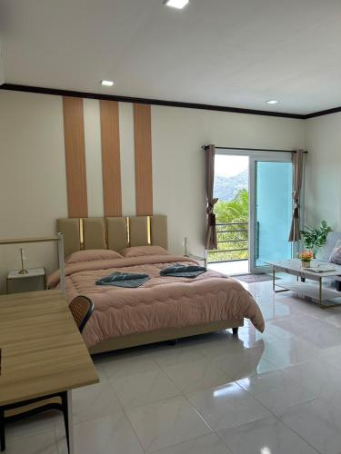 a bedroom with a large bed and a table at Khaosok Diary Camp in Khao Sok National Park