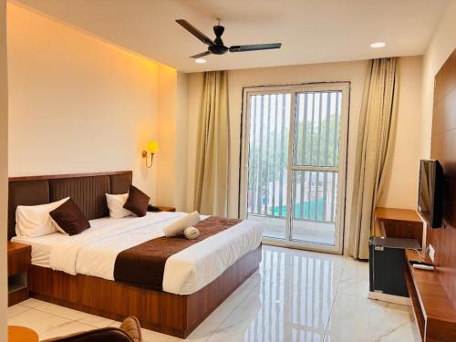 a bedroom with a bed and a large window at Hotel janki elite in Jaipur