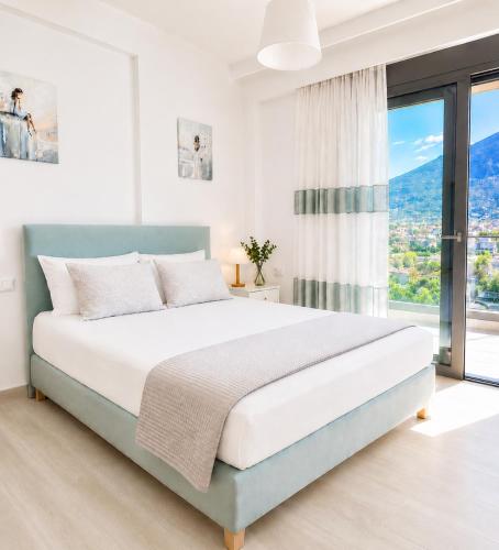a bedroom with a bed and a large window at Comfy Vista Apartment in Kalamata