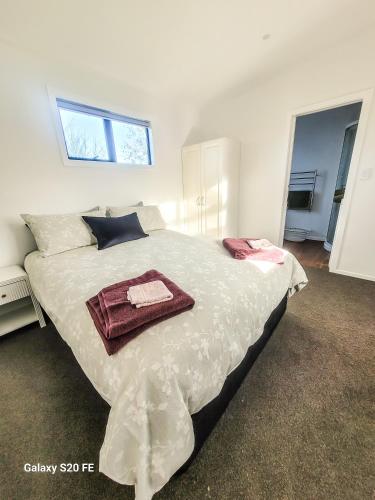 a bedroom with a large bed with two towels on it at The She Oak in Carterton