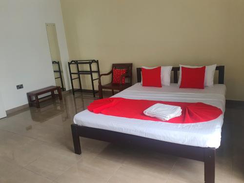 a bedroom with a large bed with red pillows at Dee Holidays - in Moratuwa