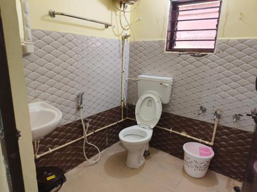 a bathroom with a toilet and a sink at Kodai blue residency in Kodaikānāl