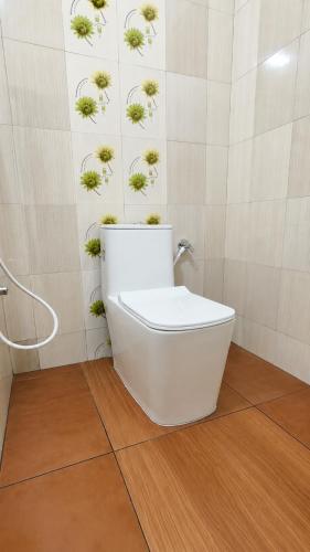 a bathroom with a toilet with plants on the wall at Canorix Inn in Athirappilly