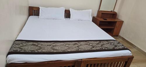 a bedroom with a bed with a white bedspread and a night stand at Kodai blue residency in Kodaikānāl