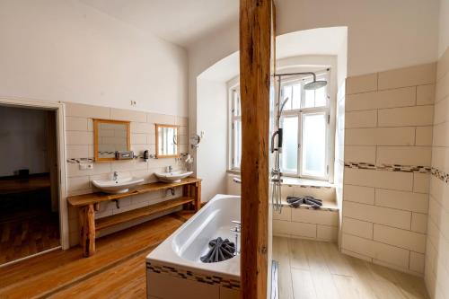 a bathroom with two sinks and a bath tub at Schloss Hotel Wurzen in Wurzen