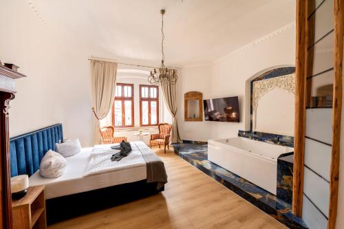 a bedroom with a bed and a tub and a sink at Schloss Hotel Wurzen in Wurzen