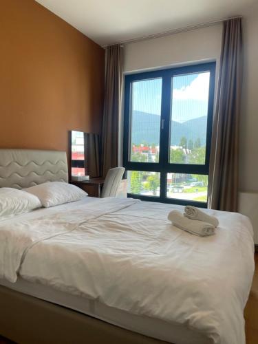 a bedroom with a bed and a large window at ilidza sky river 2 in Sarajevo