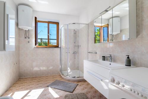 a white bathroom with a shower and a sink at Miren apartma Ankaran SP - Peaceful Apartment Ankaran SP in Ankaran