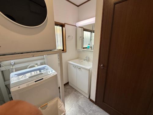 a bathroom with a sink and a washing machine at Asobico焼津 in Yaizu