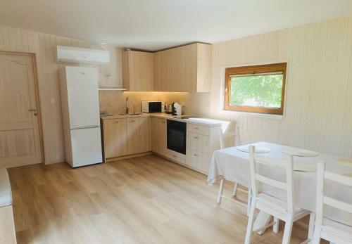a kitchen with a table and a white refrigerator at Kabakėlio slėnis in Kabakelis