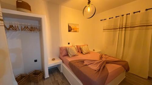 a small bedroom with a bed and a shower at PANDORA Φουρνοι Κορσεων in Nisída Foúrnoi