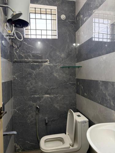 a bathroom with a toilet and a sink at Chandran Apartments in Vellore