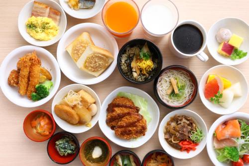a table with many plates of food on it at Dormy Inn Himeji Natural Hot Spring in Himeji