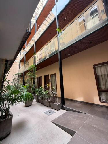a building with potted plants in a courtyard at Hamsun Shahrah-e-Faisal in Karachi