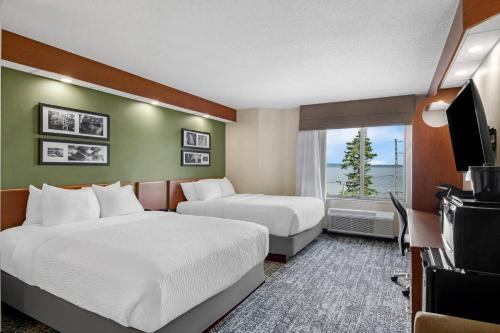 a hotel room with two beds and a television at Sleep Inn & Suites Bay View Acme - Traverse City in Traverse City
