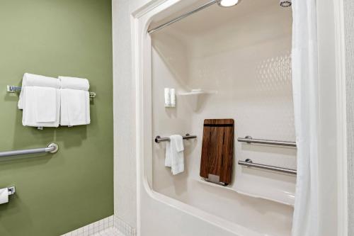 a bathroom with a shower with a mirror and towels at Sleep Inn & Suites Bay View Acme - Traverse City in Traverse City