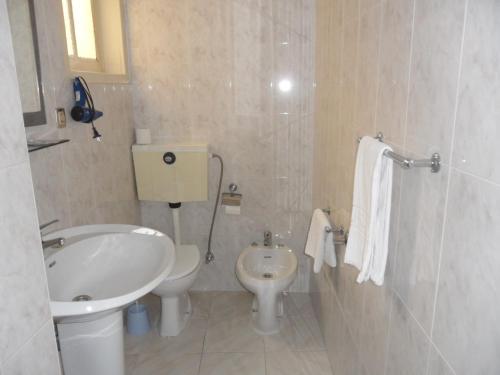 a white bathroom with a sink and a toilet at Hotel Paulista in Porto