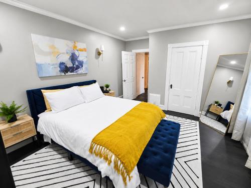 a bedroom with a large bed with a yellow blanket at Sleeps 6 Near Boston, Providence & Gillette in Attleboro