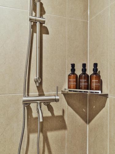 a shower with three bottles of soap on a shelf at 수수하우스 서울 in Seoul