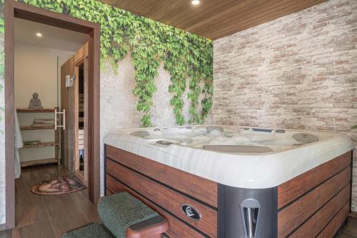 a bathroom with a jacuzzi tub next to a brick wall at Villa Vinita w/ Jacuzzi & Sauna near Thermal Spa - Happy Rentals in Sveti Jurij ob Ščavnici