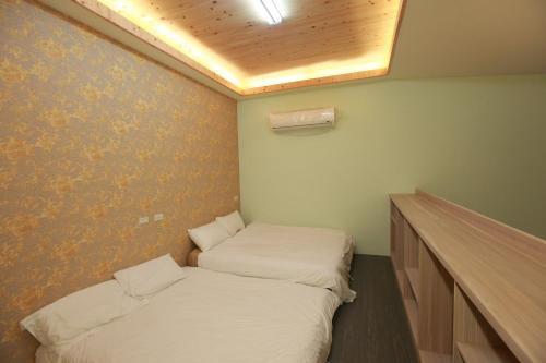 Una habitación con dos camas en ella con en Cup Runneth B&B, en Hualien City