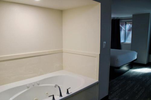 a bath tub in a room with a bathroom at The Cairn Hotel in Cedar City