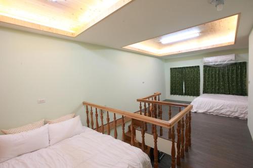 un salon avec deux lits et un escalier dans l'établissement Cup Runneth B&B, à Hualien