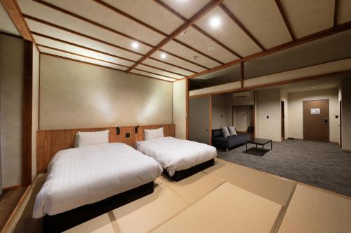 a hotel room with two beds and a couch at 西伊豆 巡り in Ukusu