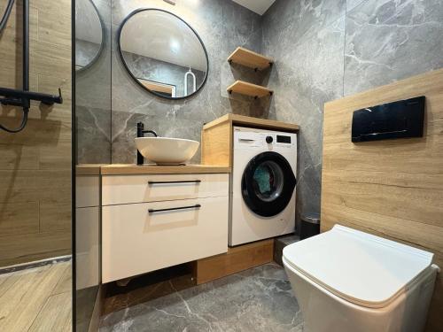 ein Badezimmer mit Waschmaschine und Waschbecken in der Unterkunft CUTE FLAT centrum in Suwałki