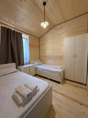 a bedroom with two beds in a wooden room at Cottage 505 in Ureki