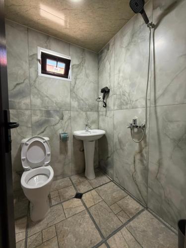 a bathroom with a toilet and a shower and a sink at Cottage 505 in Ureki