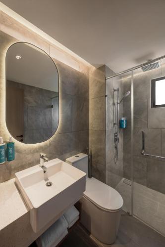a bathroom with a sink and a toilet and a mirror at Oakwood Cameron Highlands in Cameron Highlands