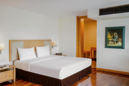 a bedroom with a large white bed in a room at The Mercer Sukhumvit 4 in Bangkok