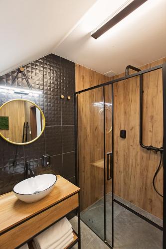 a bathroom with a sink and a shower at Apartament Wendigo - butikowy, 2-poziomowy, blisko jeziora in Szczecinek