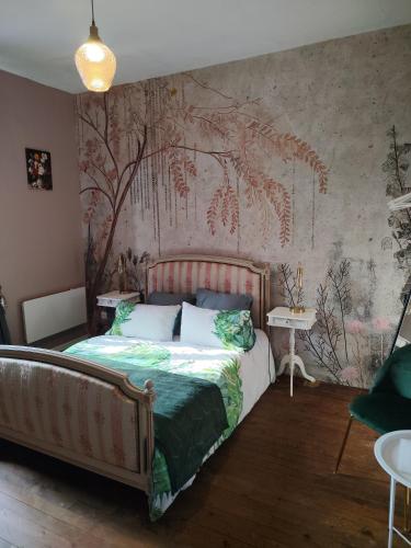 a bedroom with a bed with a painting on the wall at Cherry Blossom House in Bujaleuf