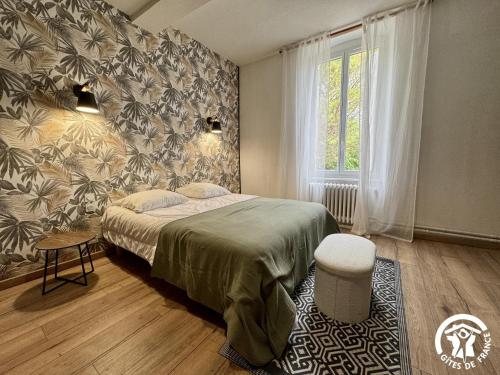 a bedroom with a bed and a large window at La prade in Saint-Ferriol