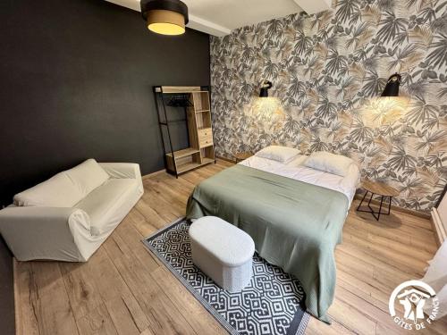 a bedroom with a bed and a couch and a chair at La prade in Saint-Ferriol