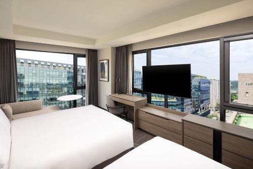 a bedroom with a bed and a flat screen tv at Hyatt Place Seoul Pangyo in Seongnam