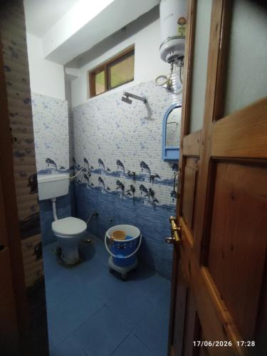 a blue bathroom with a toilet and a sink at Bhandari Cottages in Dhanaulti