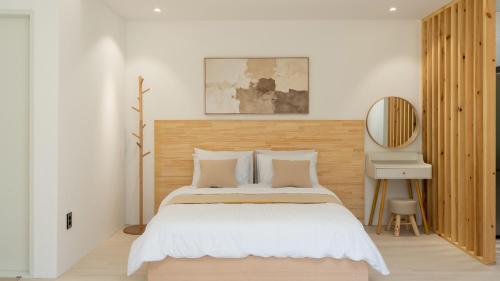 a bedroom with a large bed with a wooden headboard at Pocheon Skygaram Pension in Pocheon