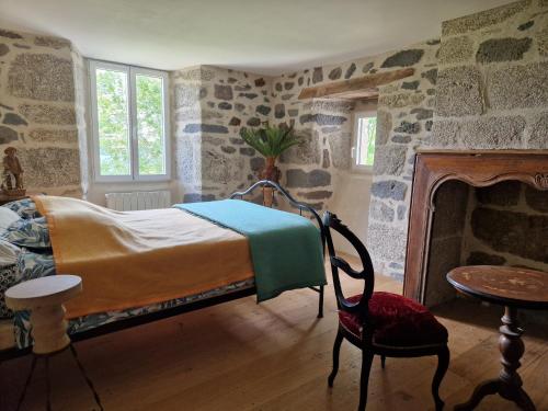 a bedroom with a bed and a stone wall at Le Domaine Eugenie in Cassuéjouls