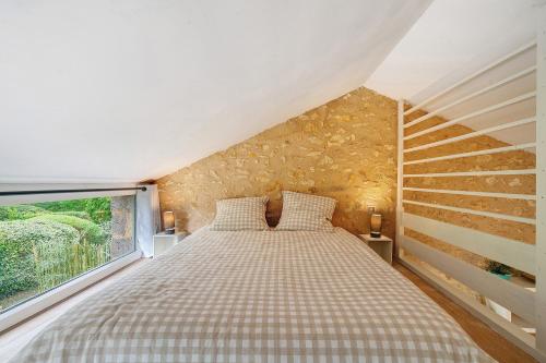 a bedroom with a bed with a large window at Gite Beauséjour in Gaugeac