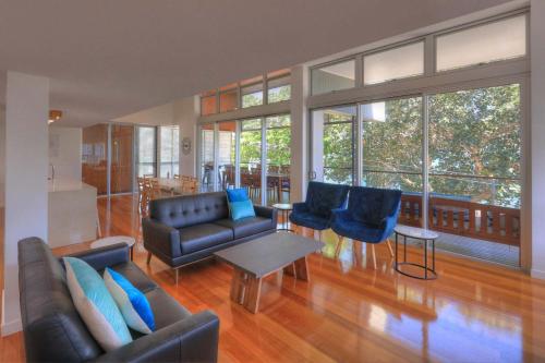 a living room with a couch and chairs and a table at Maggies Beachfront Apartment 5 in Horseshoe Bay