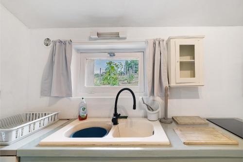 a kitchen counter with a sink and a window at Gite Beauséjour in Gaugeac